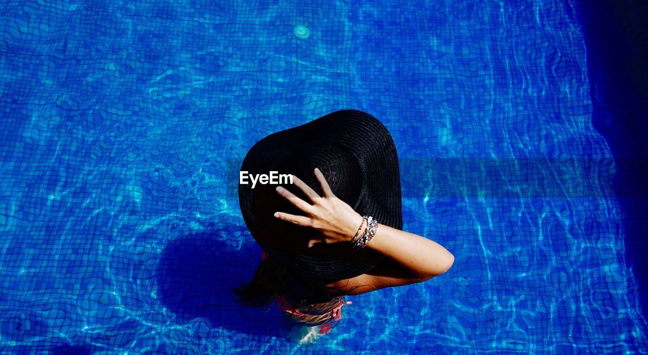 High angle view of woman wearing sun hat in swimming pool