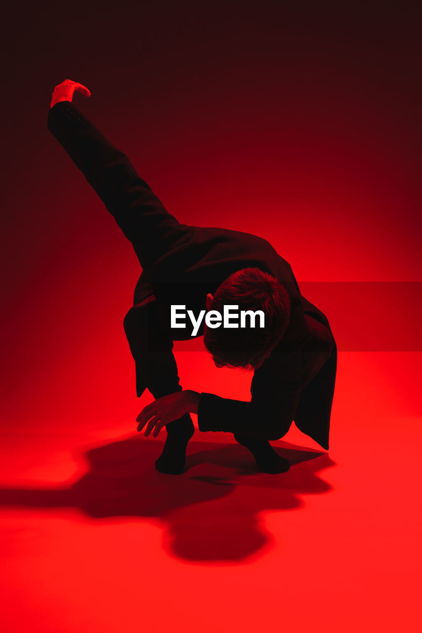 Man dancing against red background