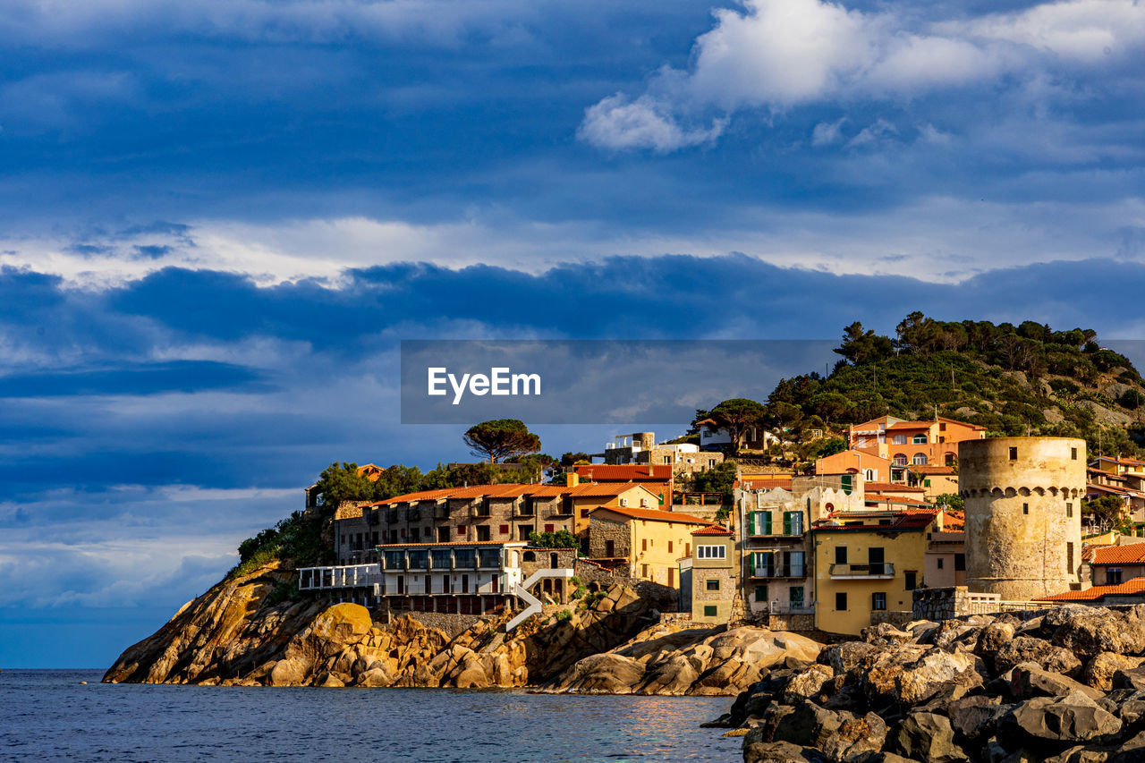 BUILDINGS AND SEA AGAINST SKY IN CITY