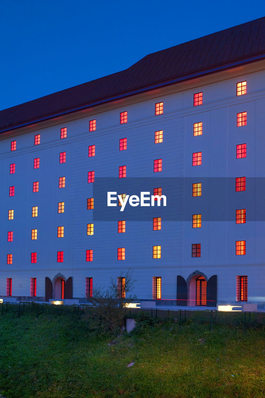 ILLUMINATED BUILDING AGAINST CLEAR SKY AT DUSK