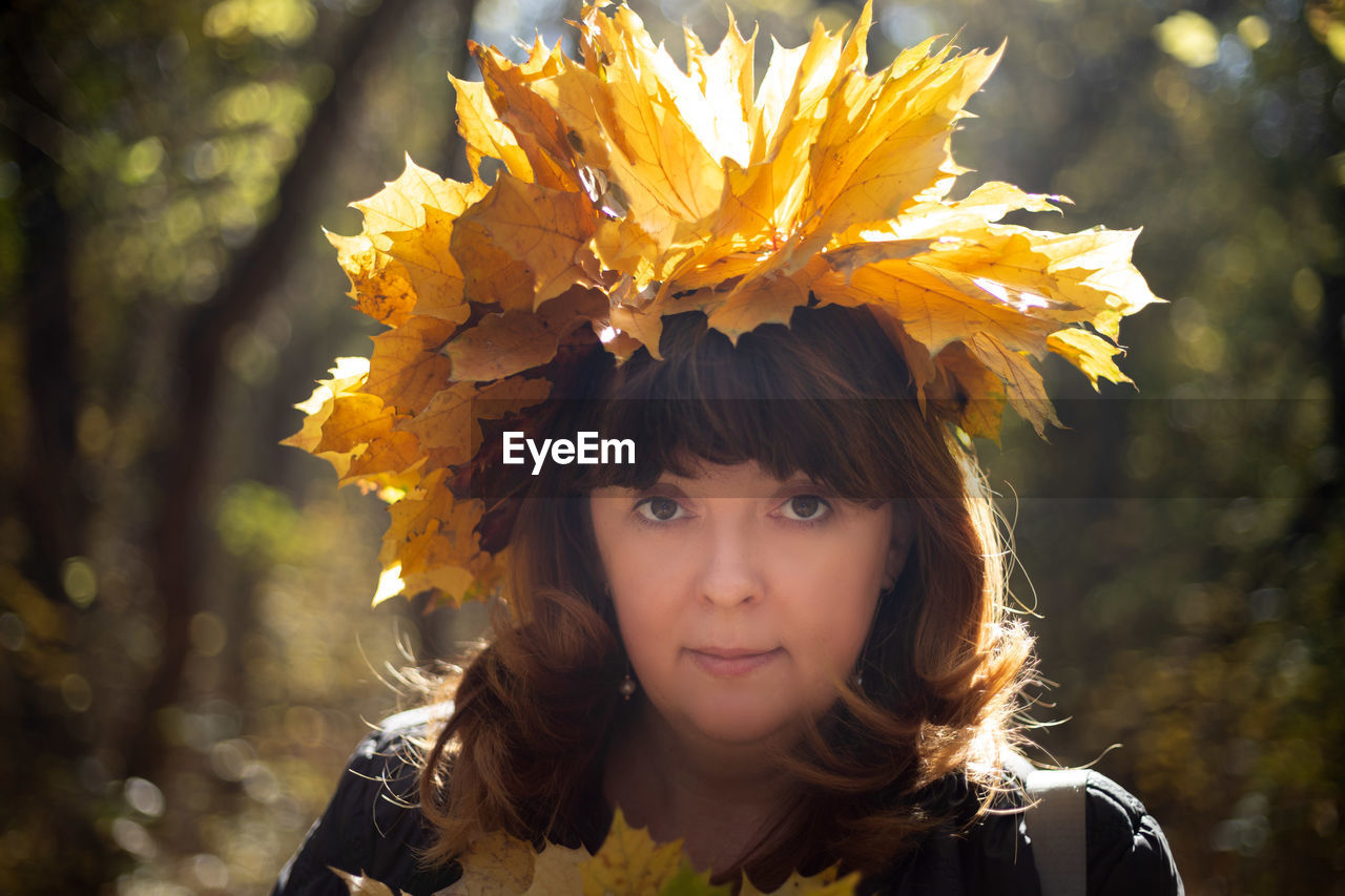 Close-up portrait of woman with leaves on head