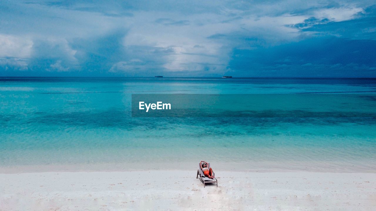 Woman chilling on the white sand beach