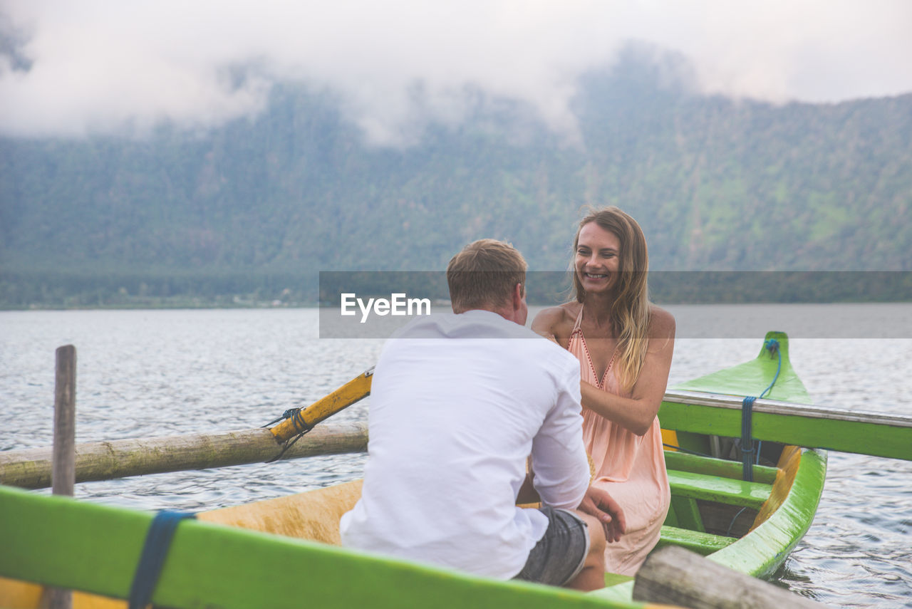 Couple in outrigger boat on lake