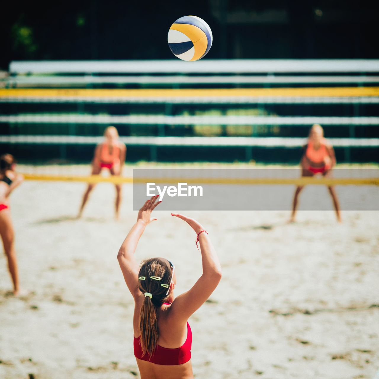 Rear view of woman playing beach volleyball