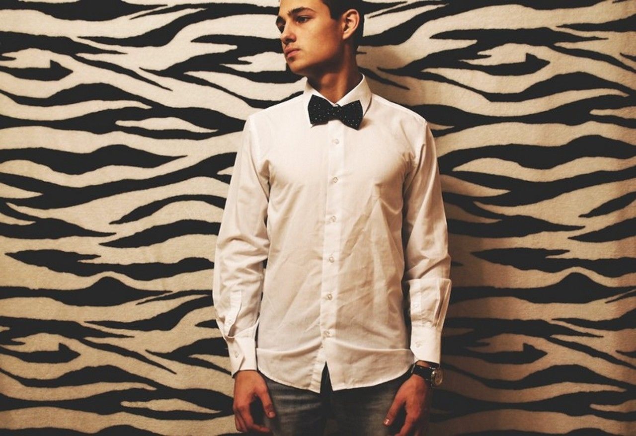 Young man standing against patterned wall