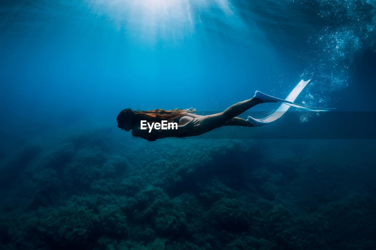 side view of woman swimming in sea