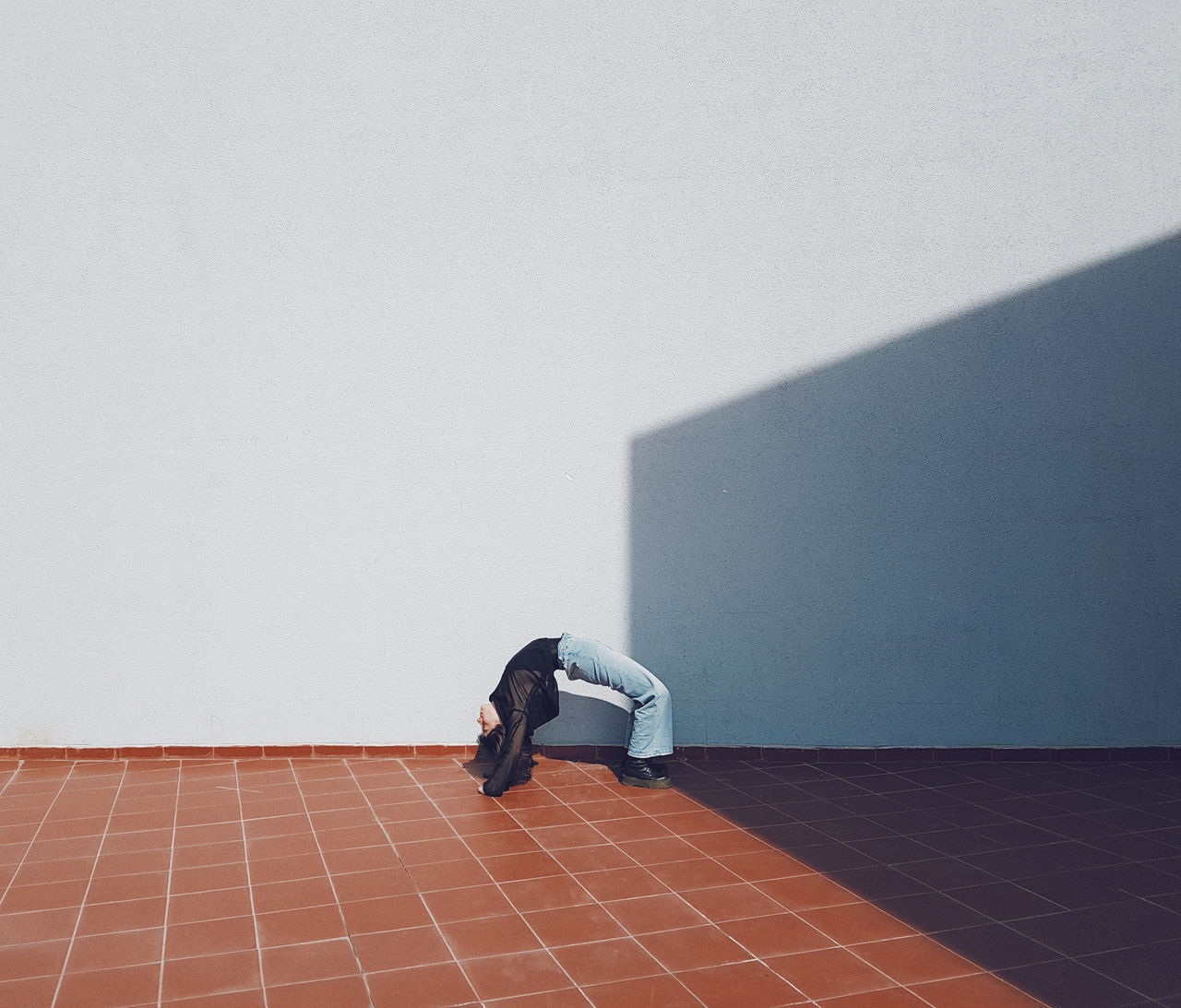 Full length of man relaxing on floor against wall