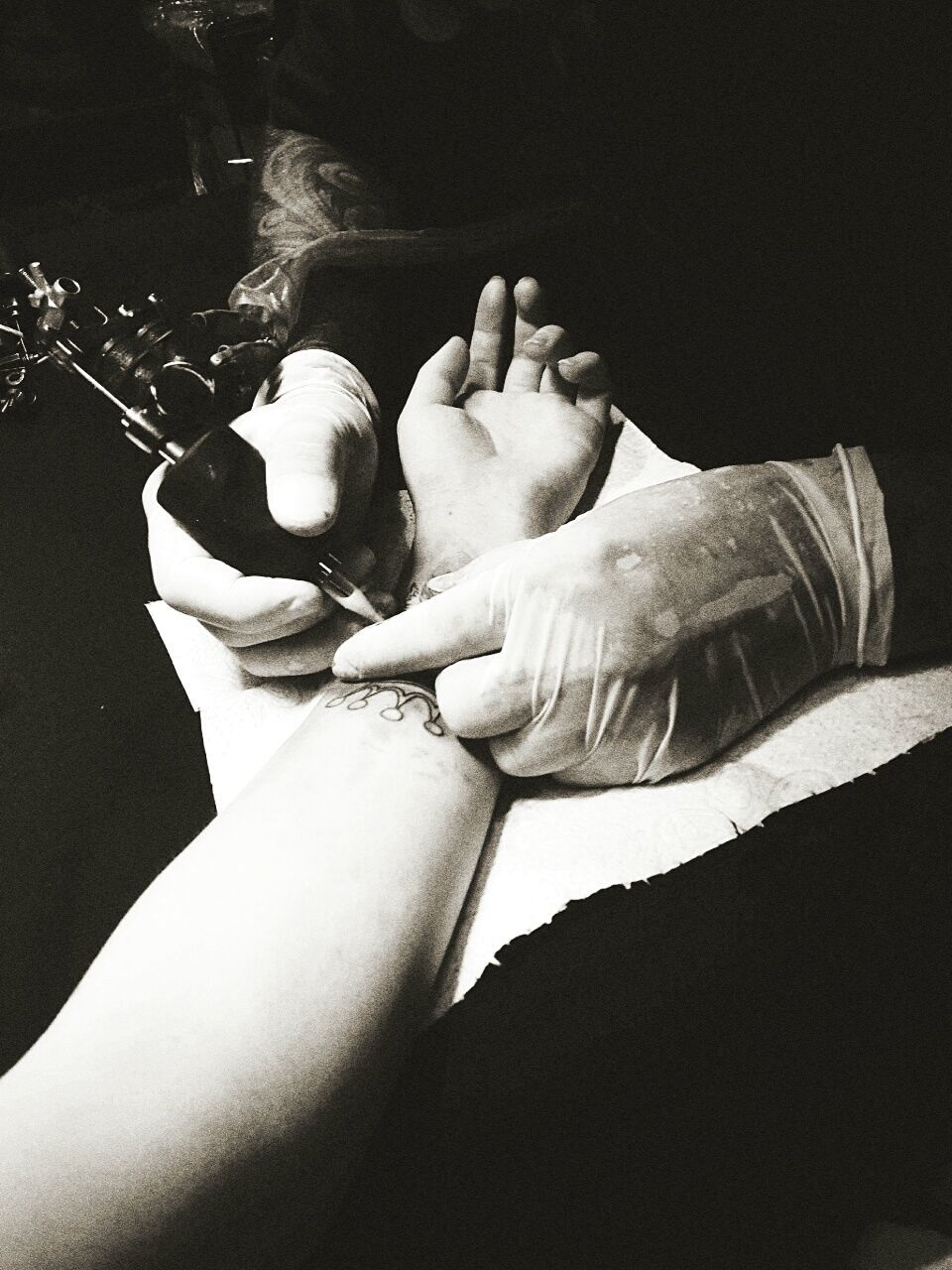 Cropped image of artist tattooing on hand at art studio