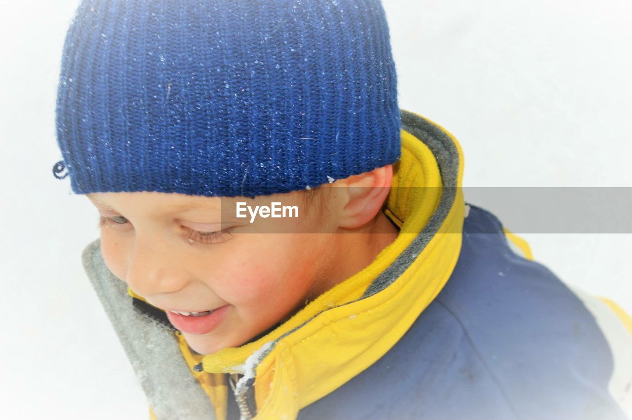 Close-up of smiling boy wearing knit hat during winter