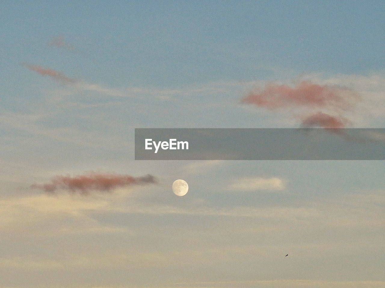 LOW ANGLE VIEW OF MOON IN CLOUDY SKY