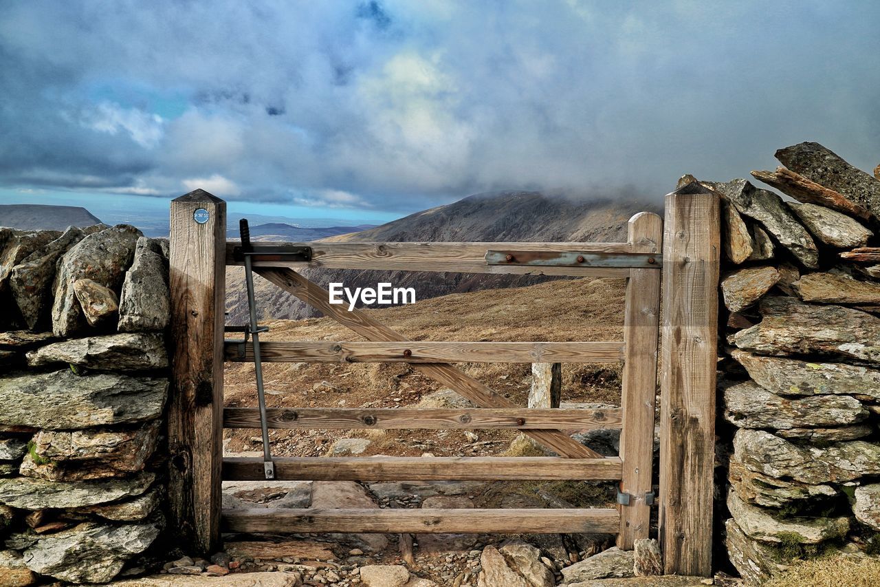 Wooden posts on mountain against sky