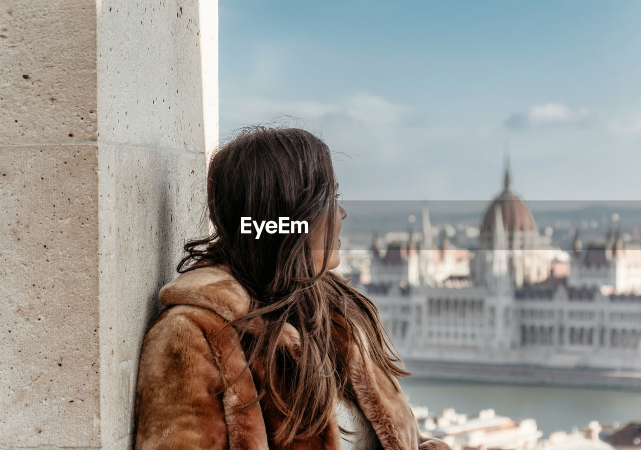 Sider view of young woman in front of cityscape of budapest, hungary