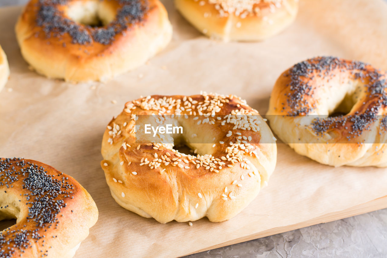 Baked bagels with poppy seeds and sesame seeds on parchment on the table. homemade pastries