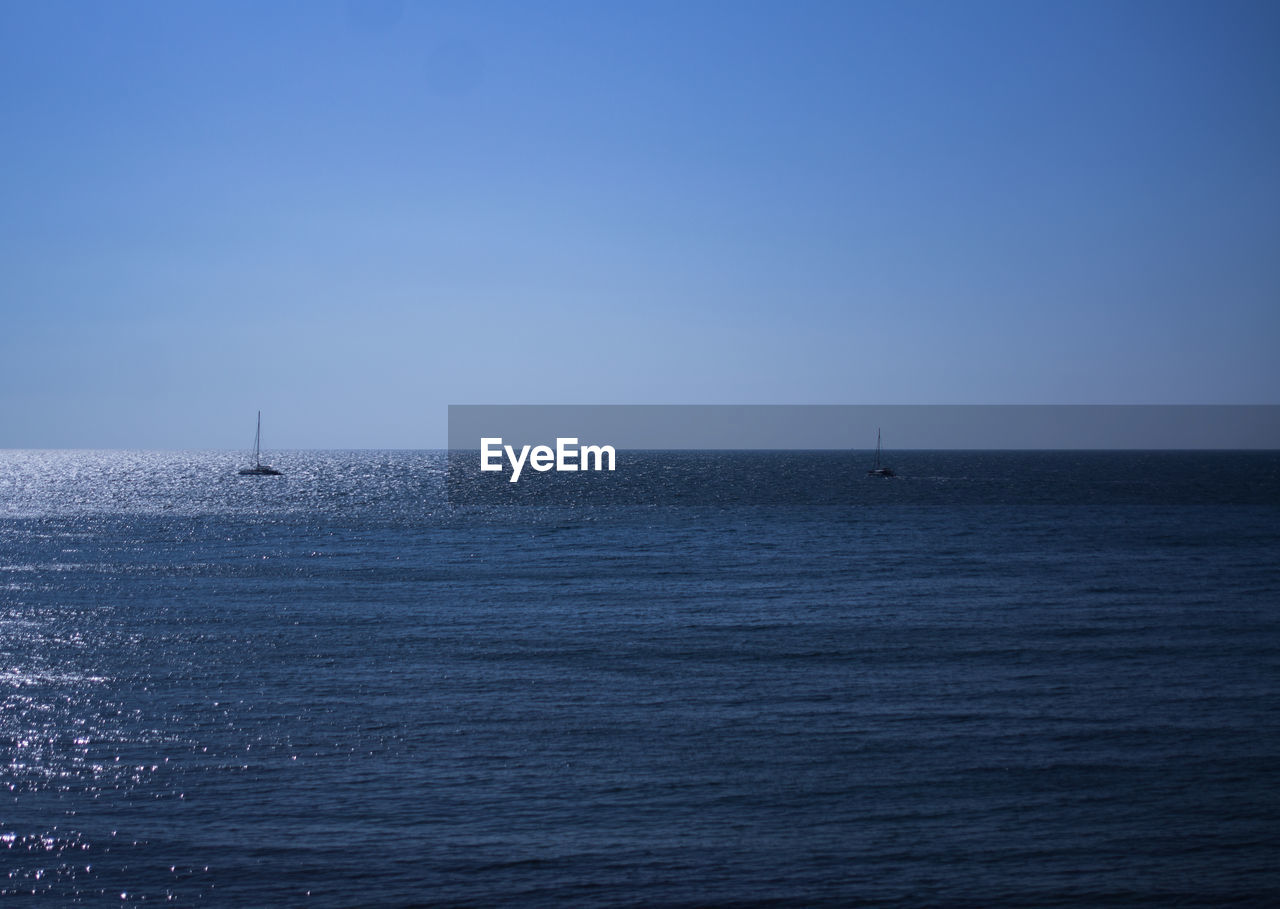 SAILBOAT IN SEA AGAINST CLEAR BLUE SKY