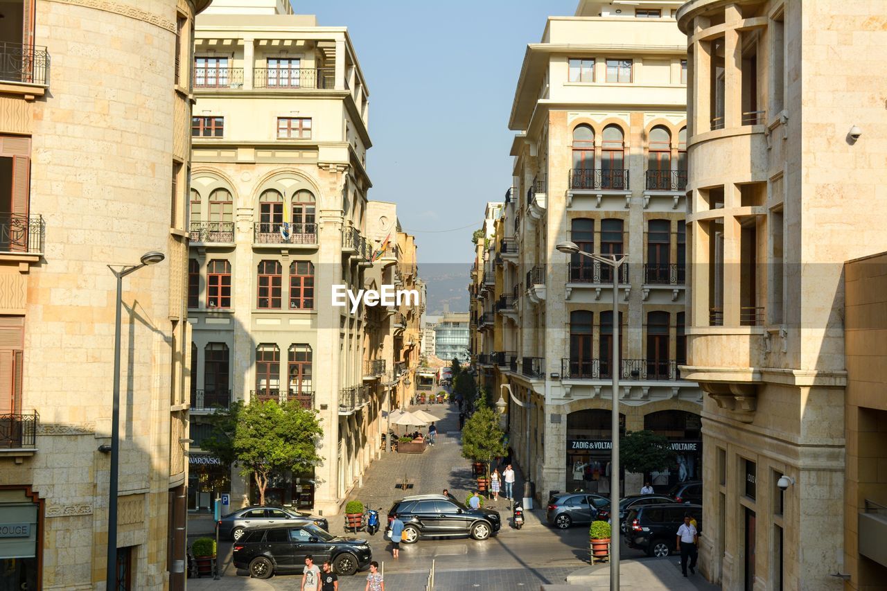 High angle view of people and vehicles on street during sunny day