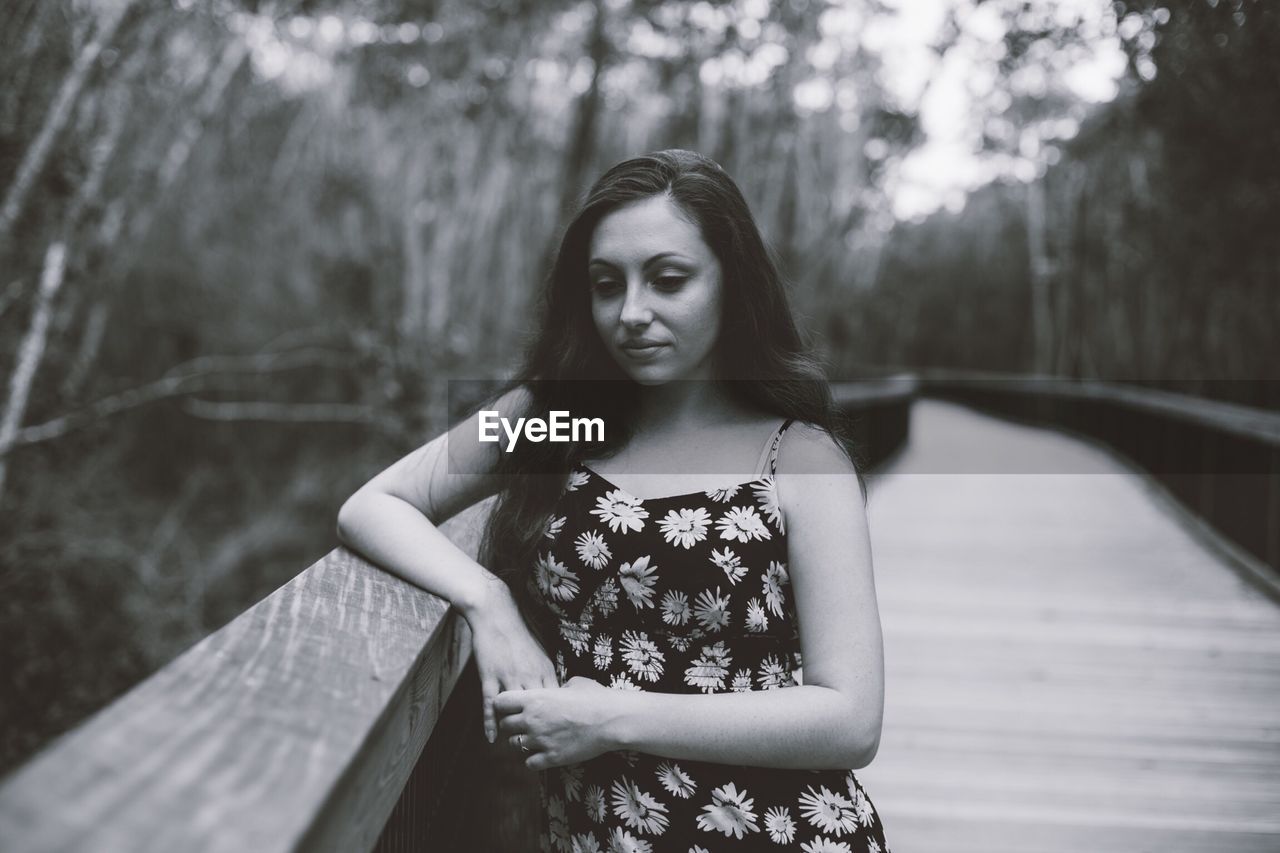 Beautiful young woman standing on bridge