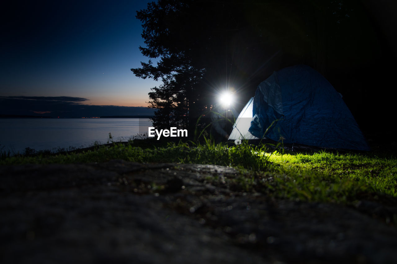 Woman camping on field at night