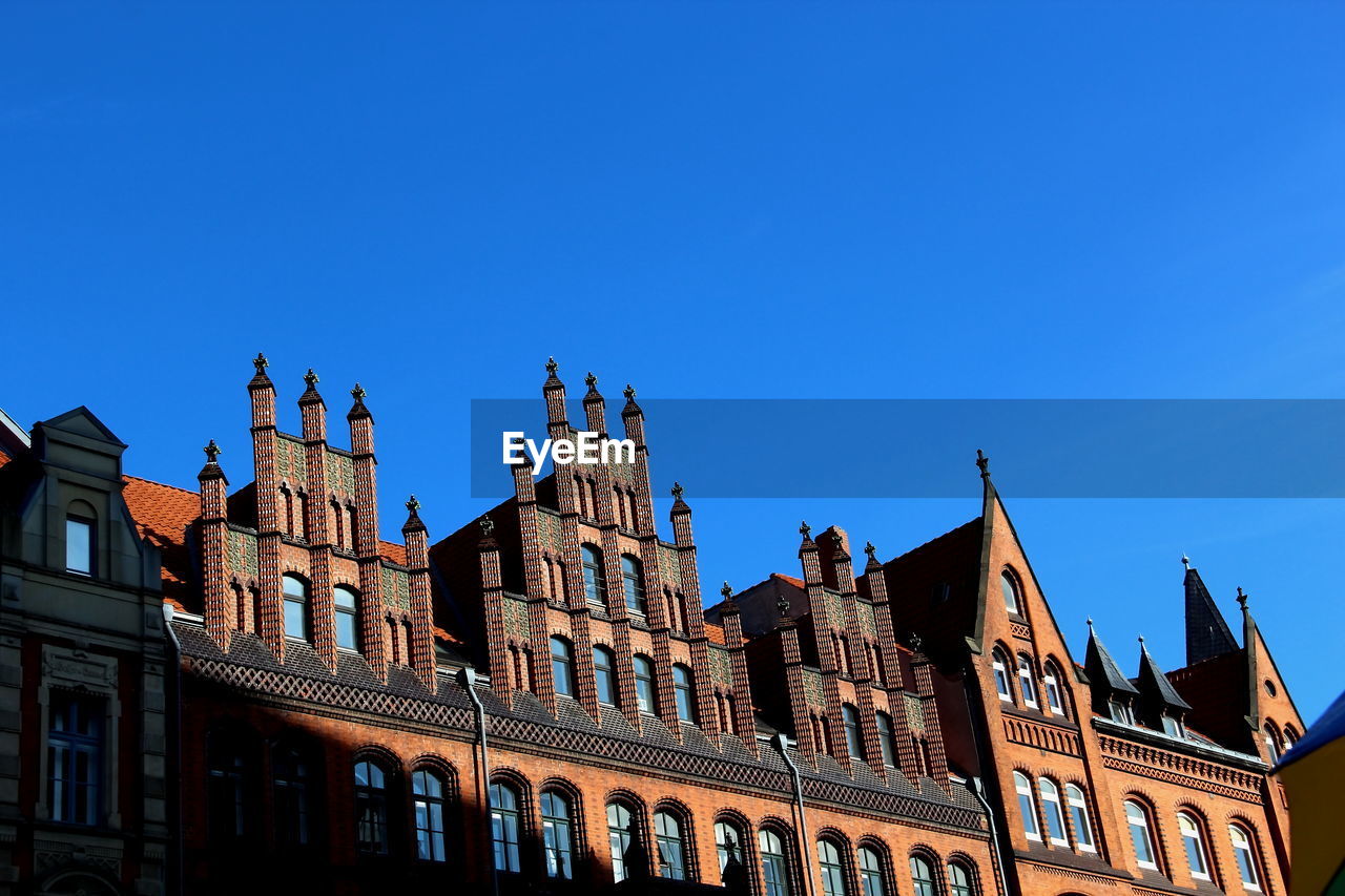 LOW ANGLE VIEW OF BUILT STRUCTURE AGAINST BLUE SKY