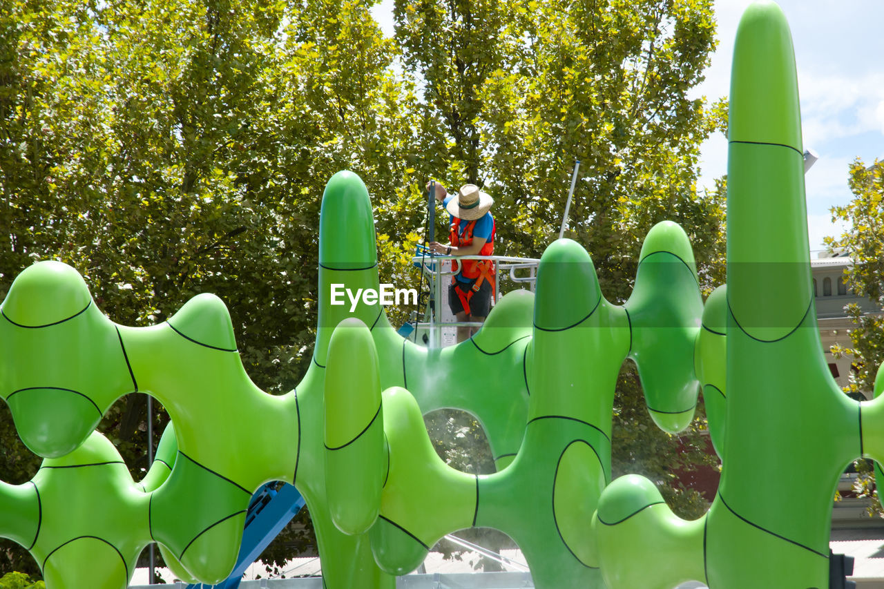 BOY PLAYING IN PARK AGAINST TREES