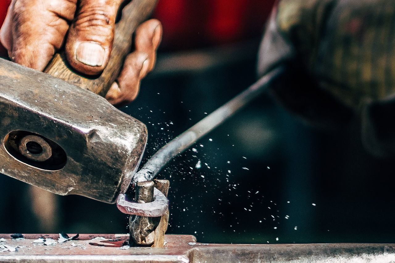 Cropped image of blacksmith working on metal