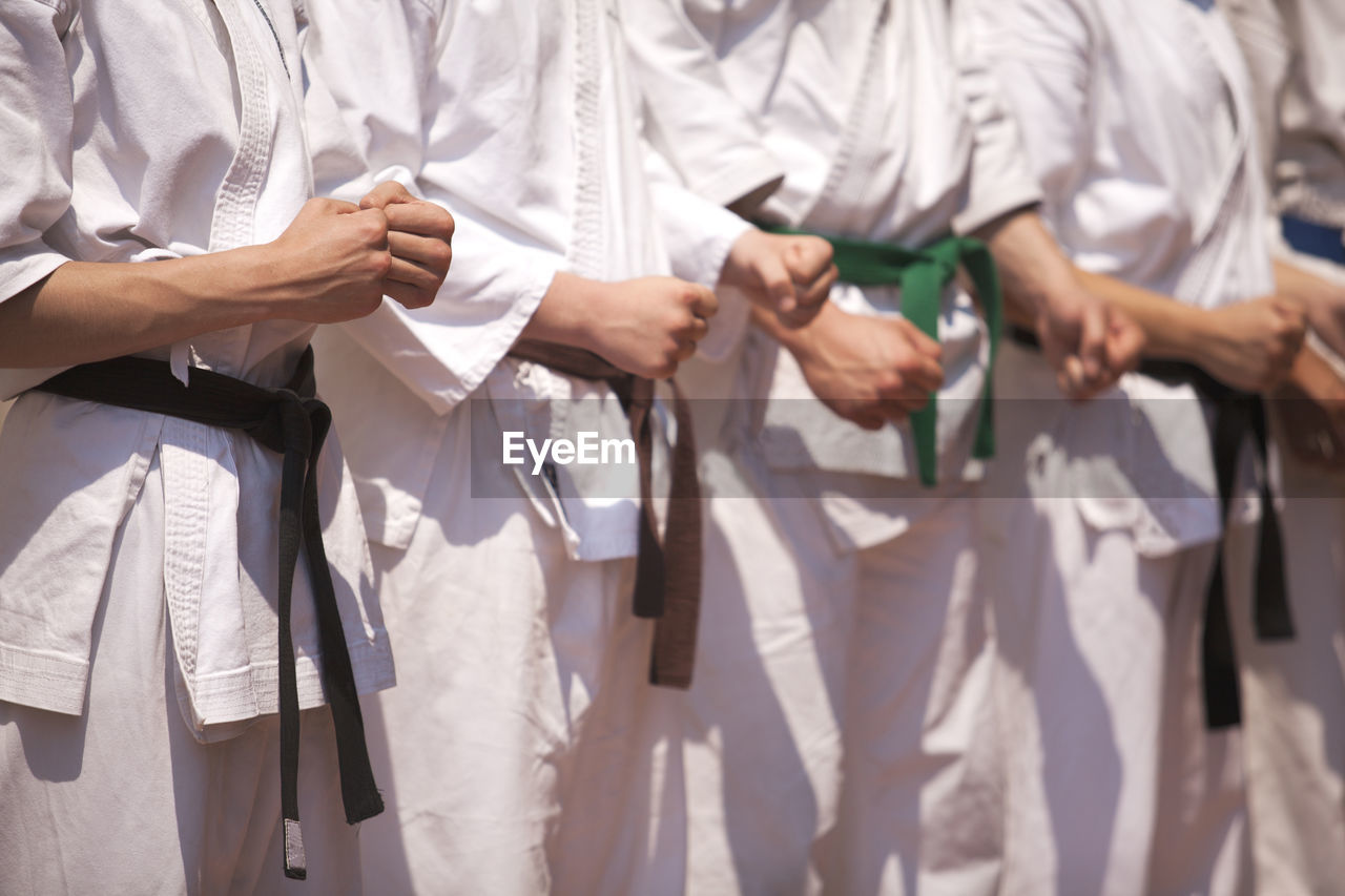 Midsection of people performing karate