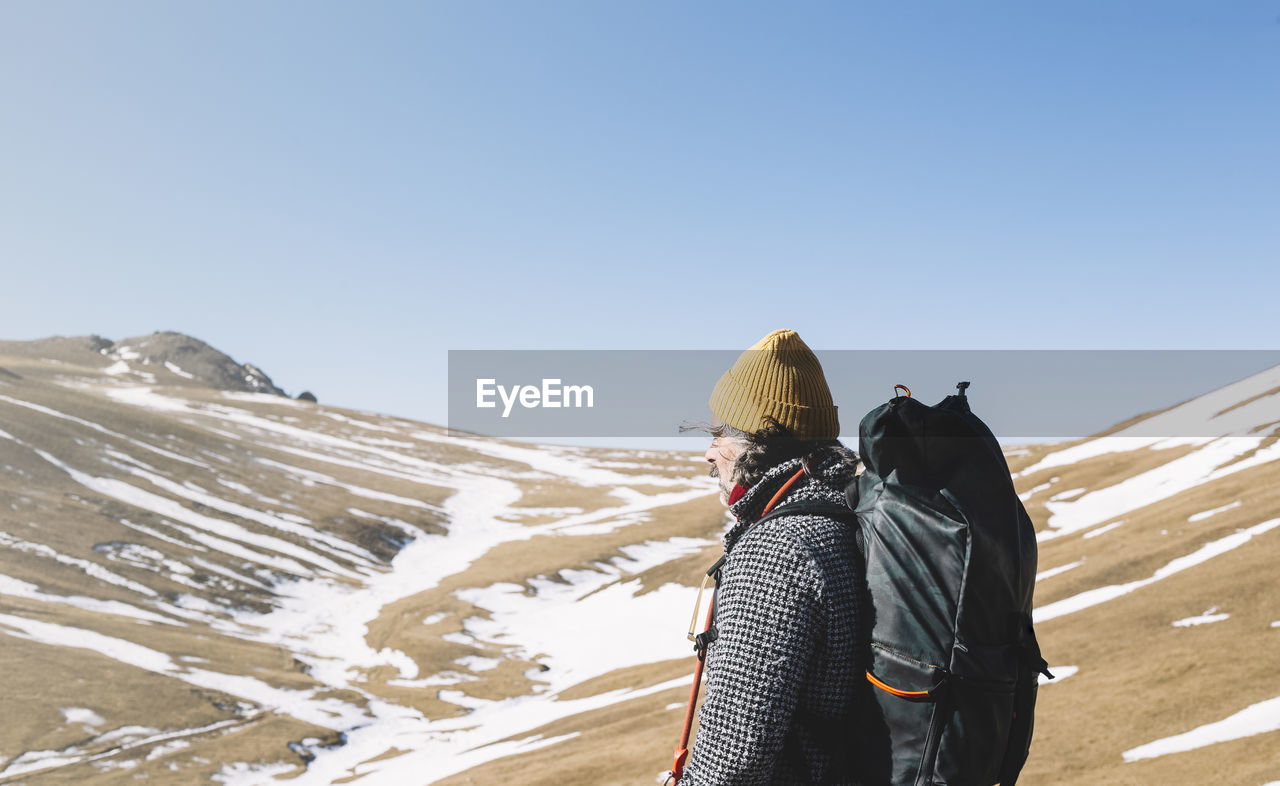 Time to think. handsome bearded hiker with backpack standing looking at copyspace