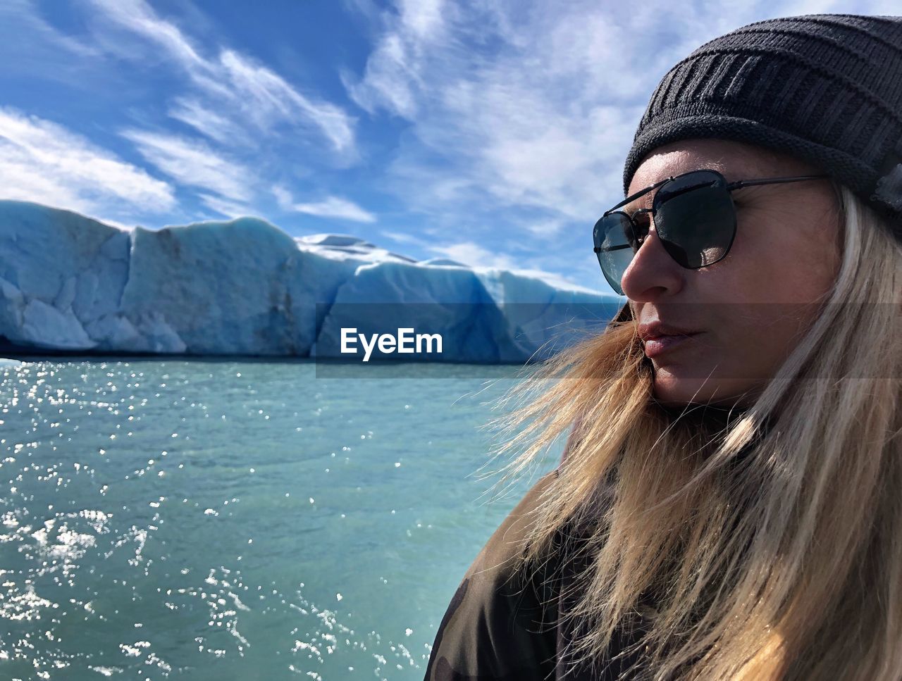 Close-up of young woman wearing sunglasses against sea and sky