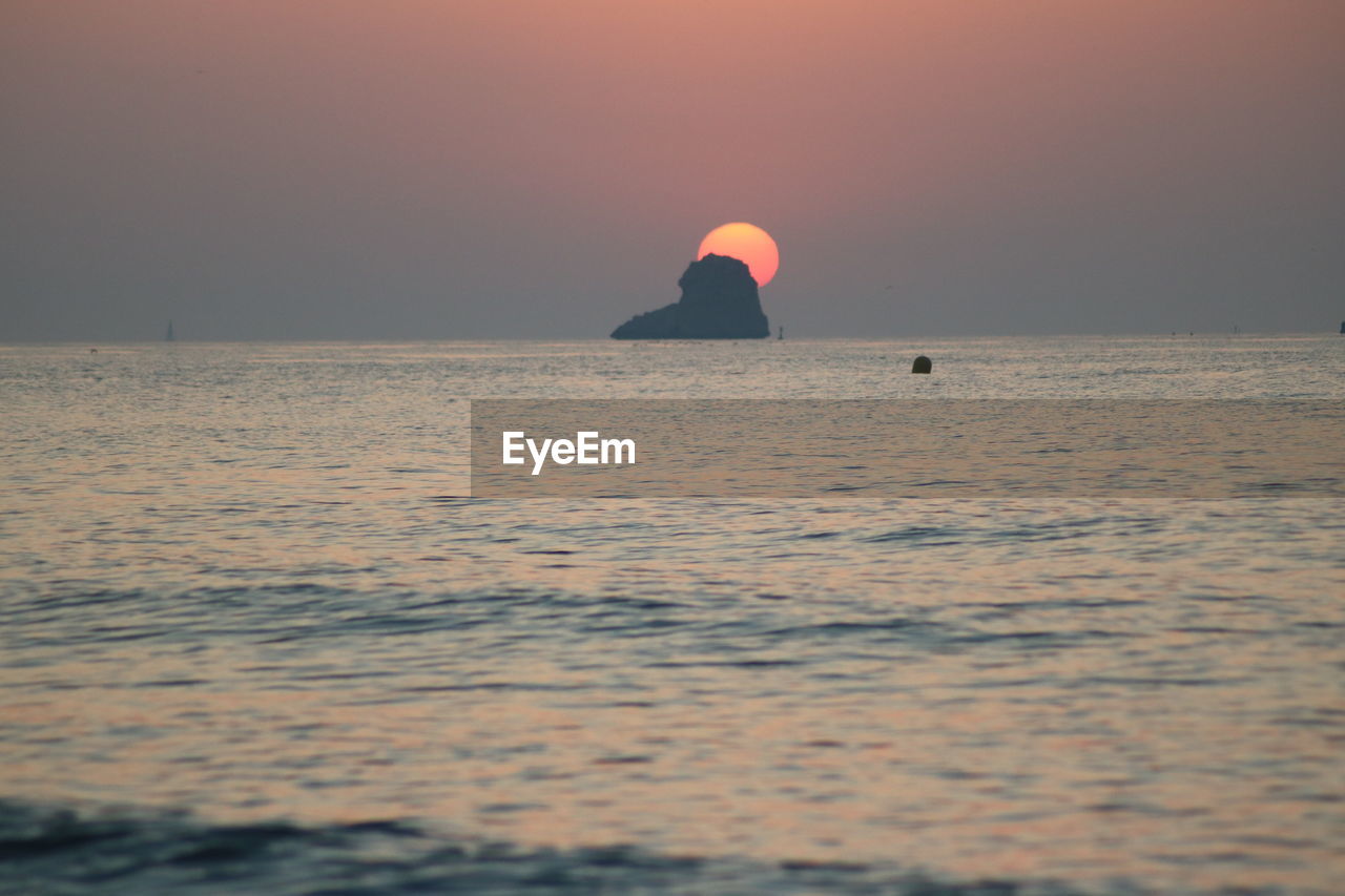 SCENIC VIEW OF SEA AGAINST ORANGE SKY