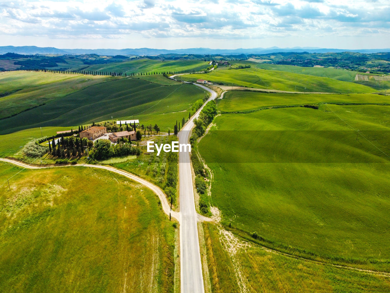 High angle view of road amidst field against sky