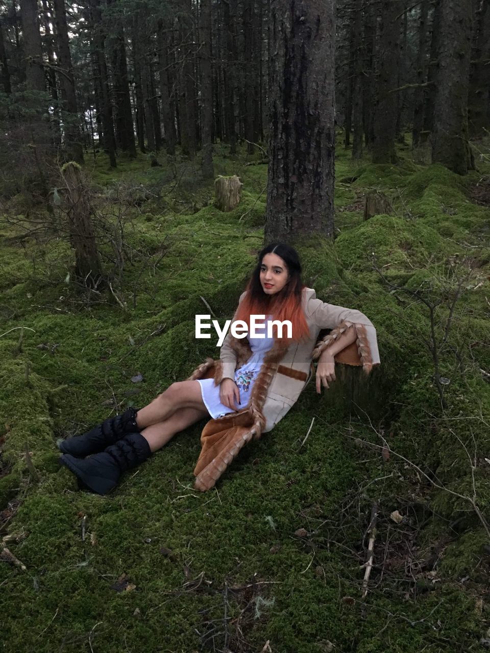 High angle view of teenage girl sitting in forest