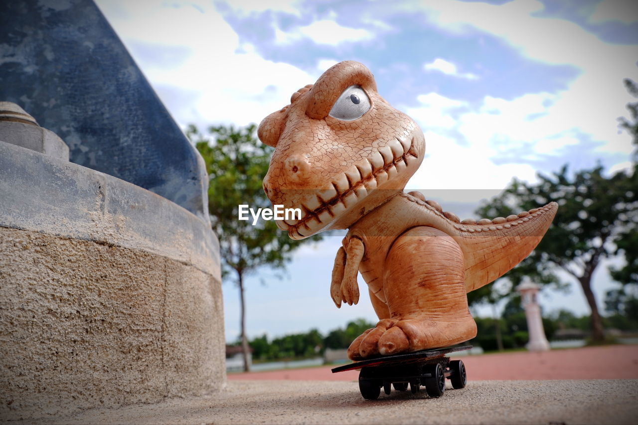 Close-up of toy statue against sky