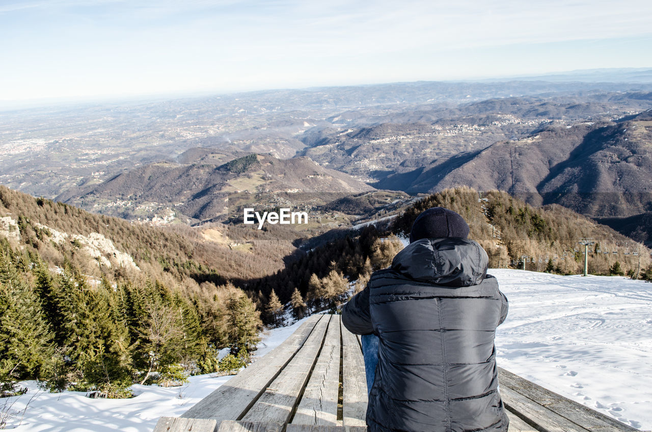 Man looking at mountains against sky
