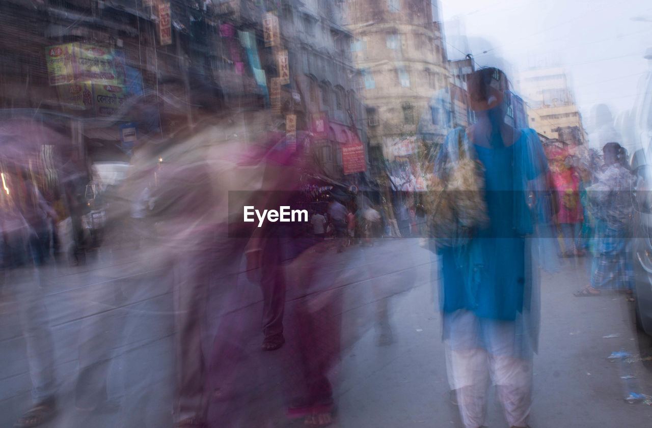 PEOPLE WALKING ON ROAD IN CITY