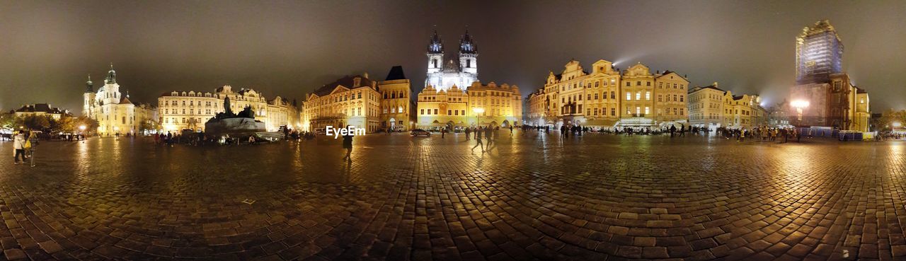 PANORAMIC VIEW OF ILLUMINATED CATHEDRAL IN CITY AGAINST SKY AT NIGHT