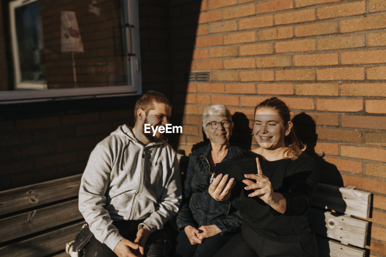 Grandmother with adult grandchildren taking selfie