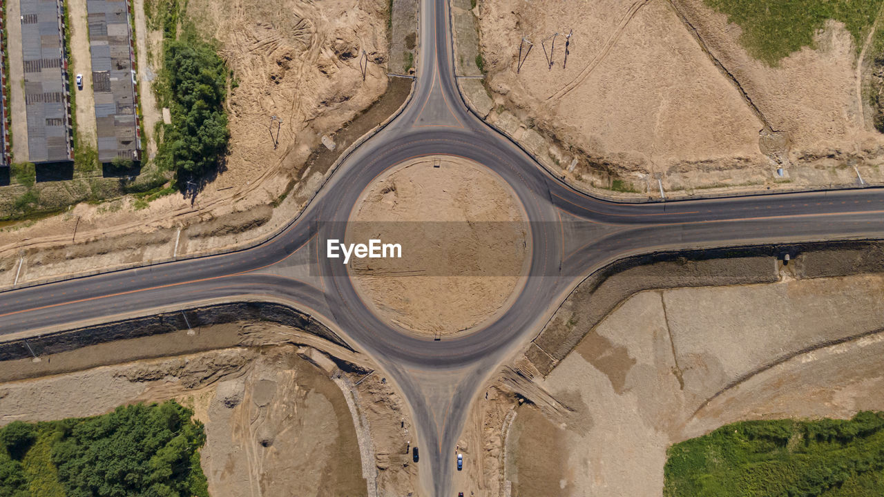 Roundabout traffic of cars and trucks on the circle ring road aerial top view. 