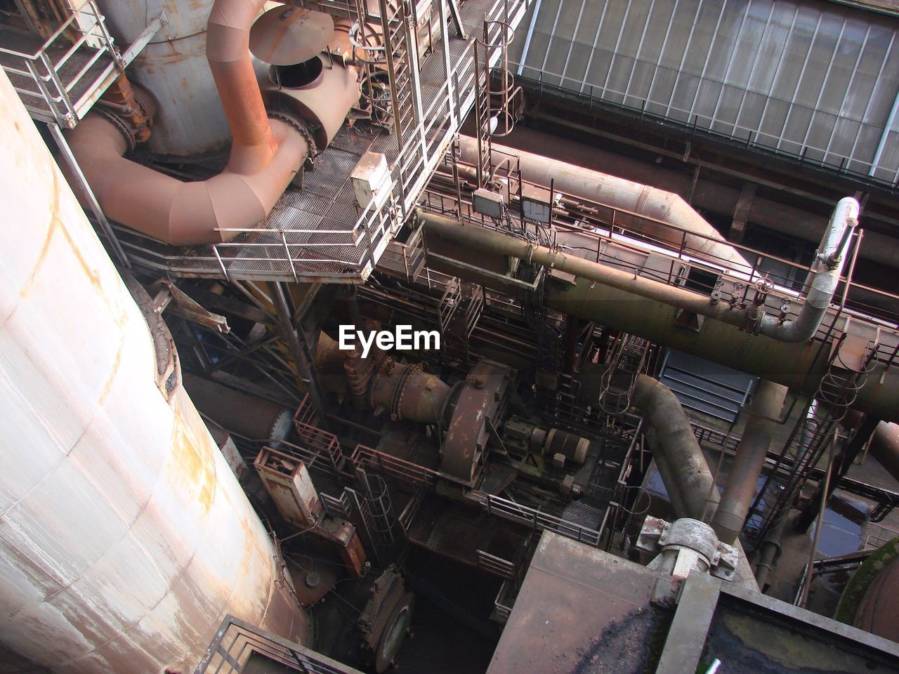 HIGH ANGLE VIEW OF MAN WORKING ON METAL FACTORY