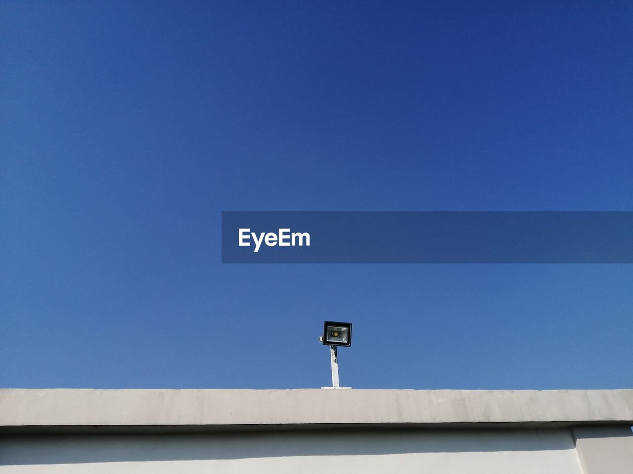 Low angle view of communications tower against blue sky