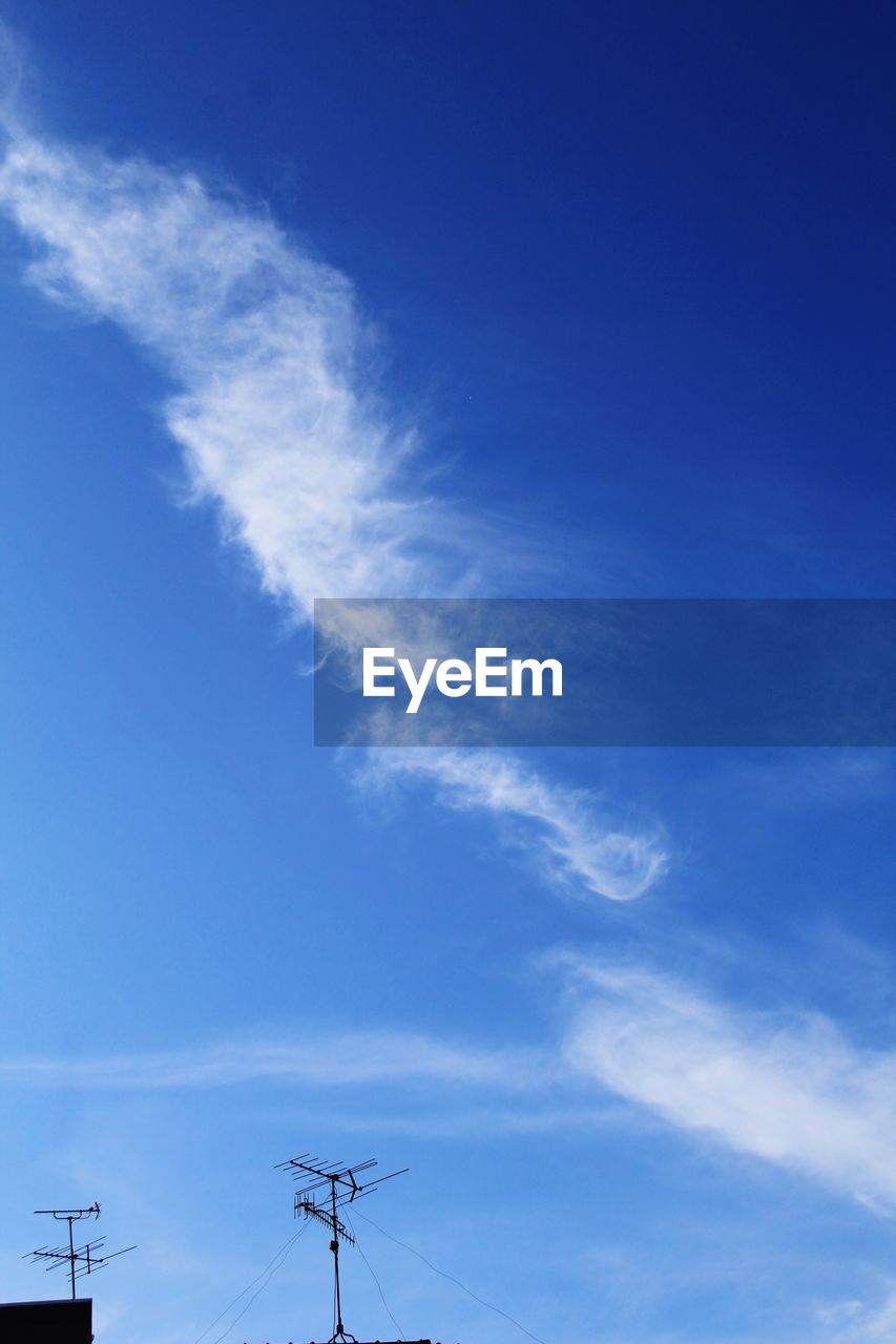 Low angle view of electricity pylon against blue sky