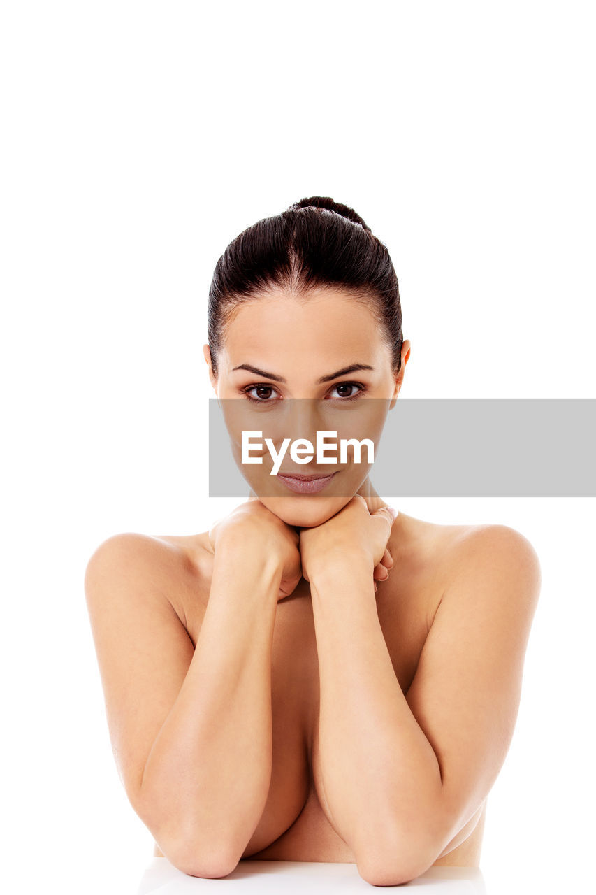 Portrait of smiling shirtless young woman against white background