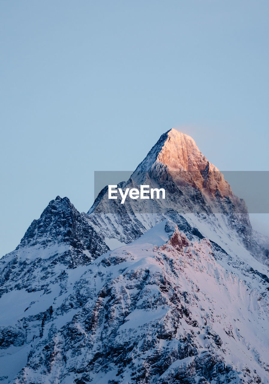 Scenic view of snowcapped schreckhorn mountain against clear blue sky