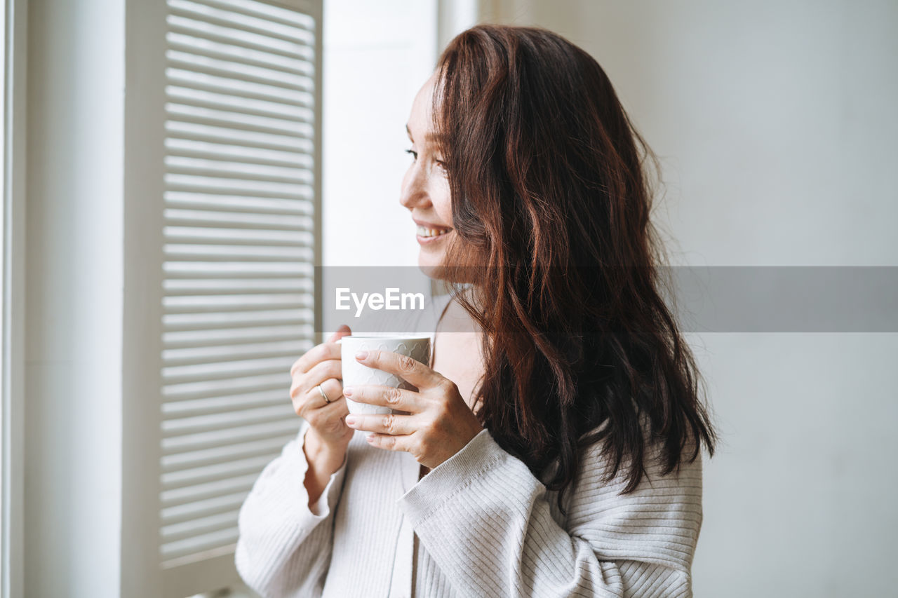 Young woman drinking coffee at home 