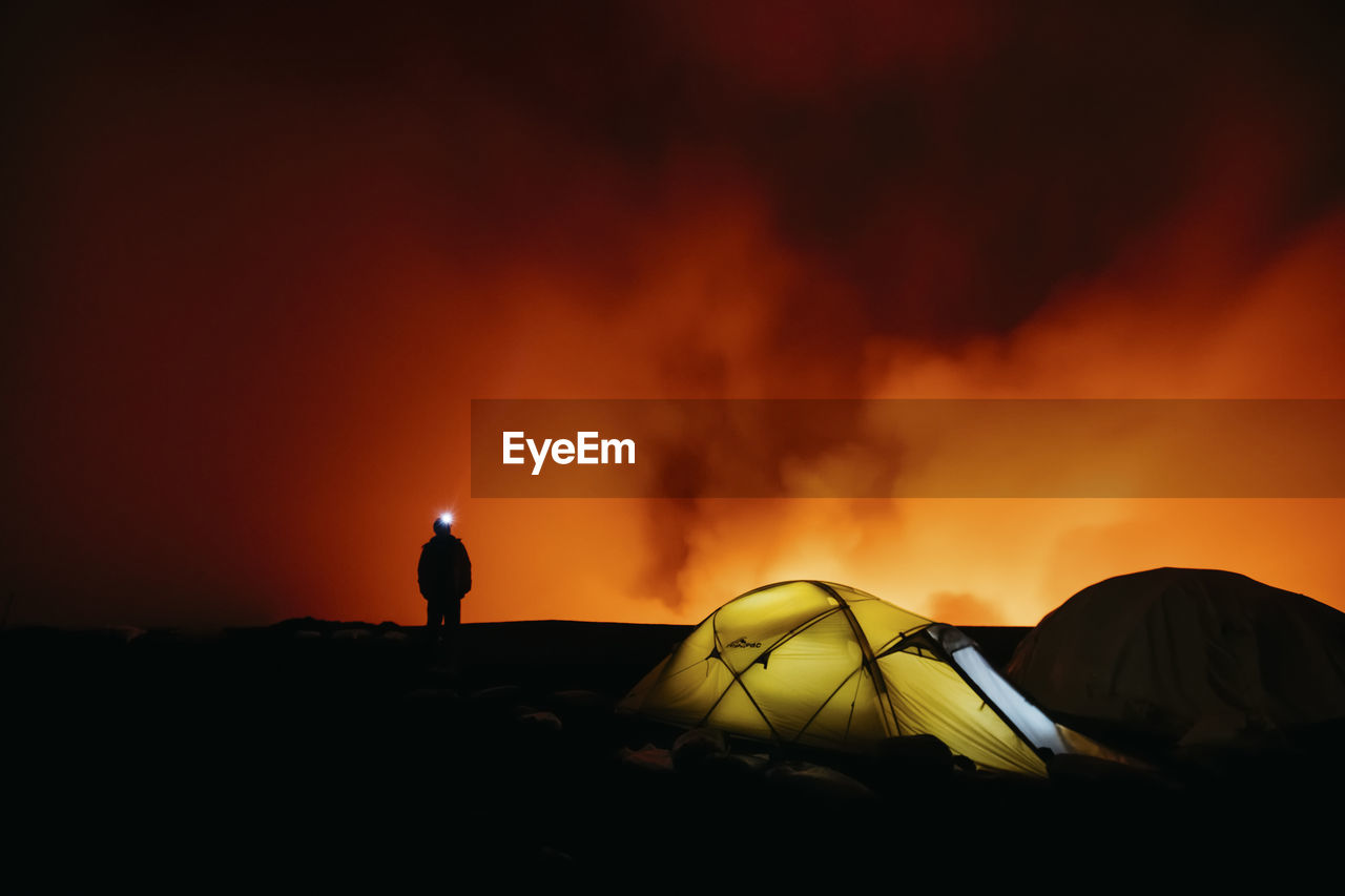 Man volcano light tent camping night