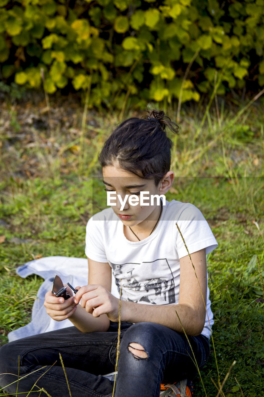 Girl sitting on field at park