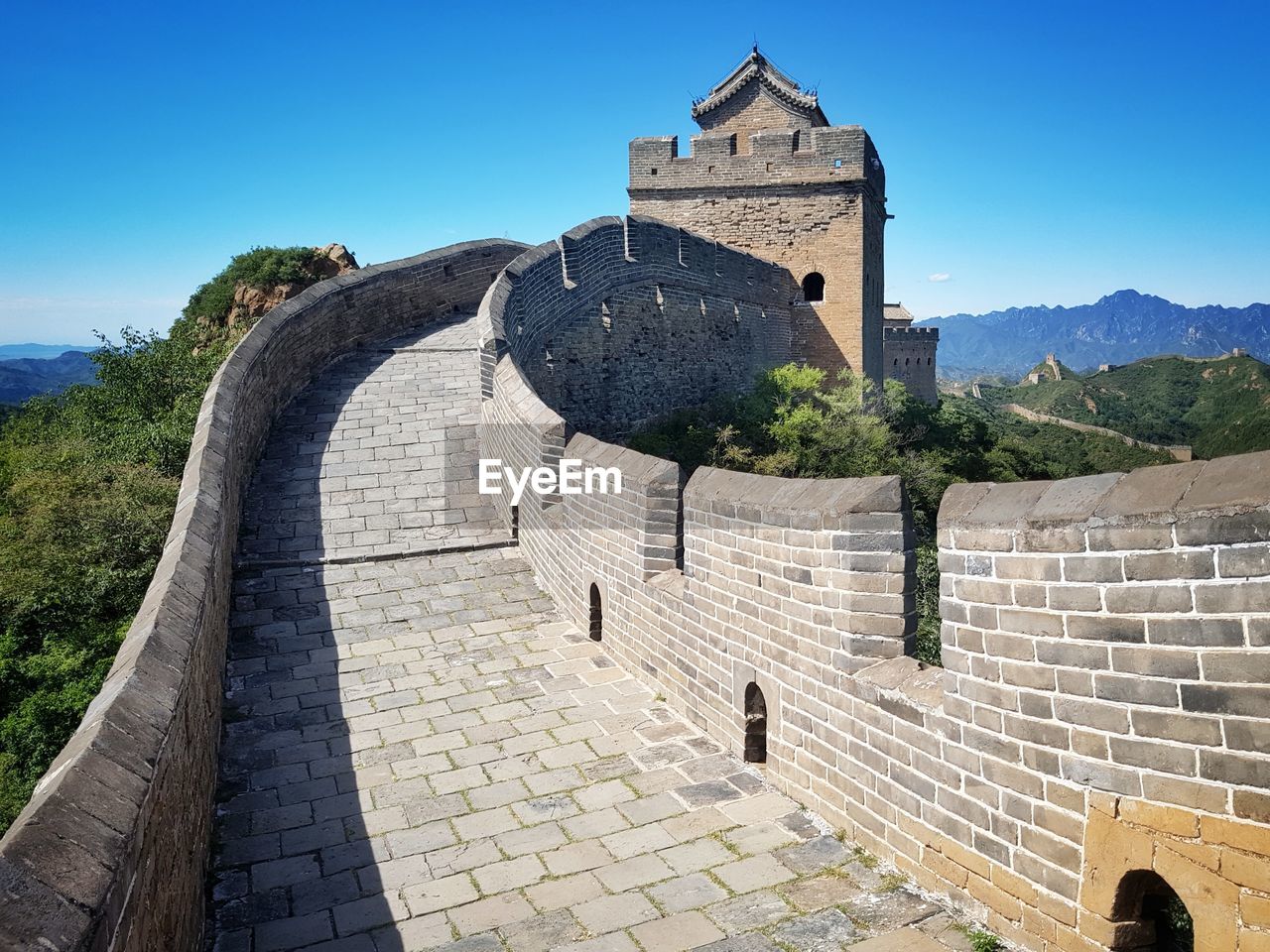 Walkway at great wall of china against clear blue sky on sunny day