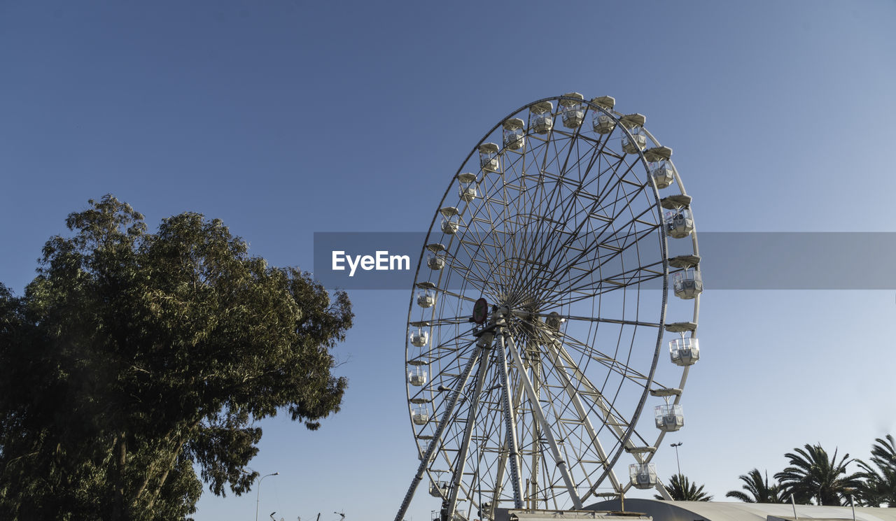 LOW ANGLE VIEW OF FERRIS WHEEL AGAINST BLUE SKY