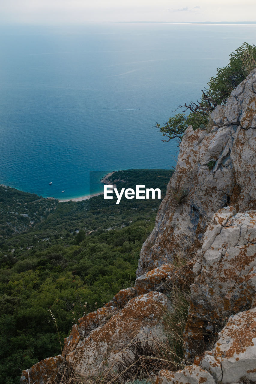 Rock formations by sea against sky