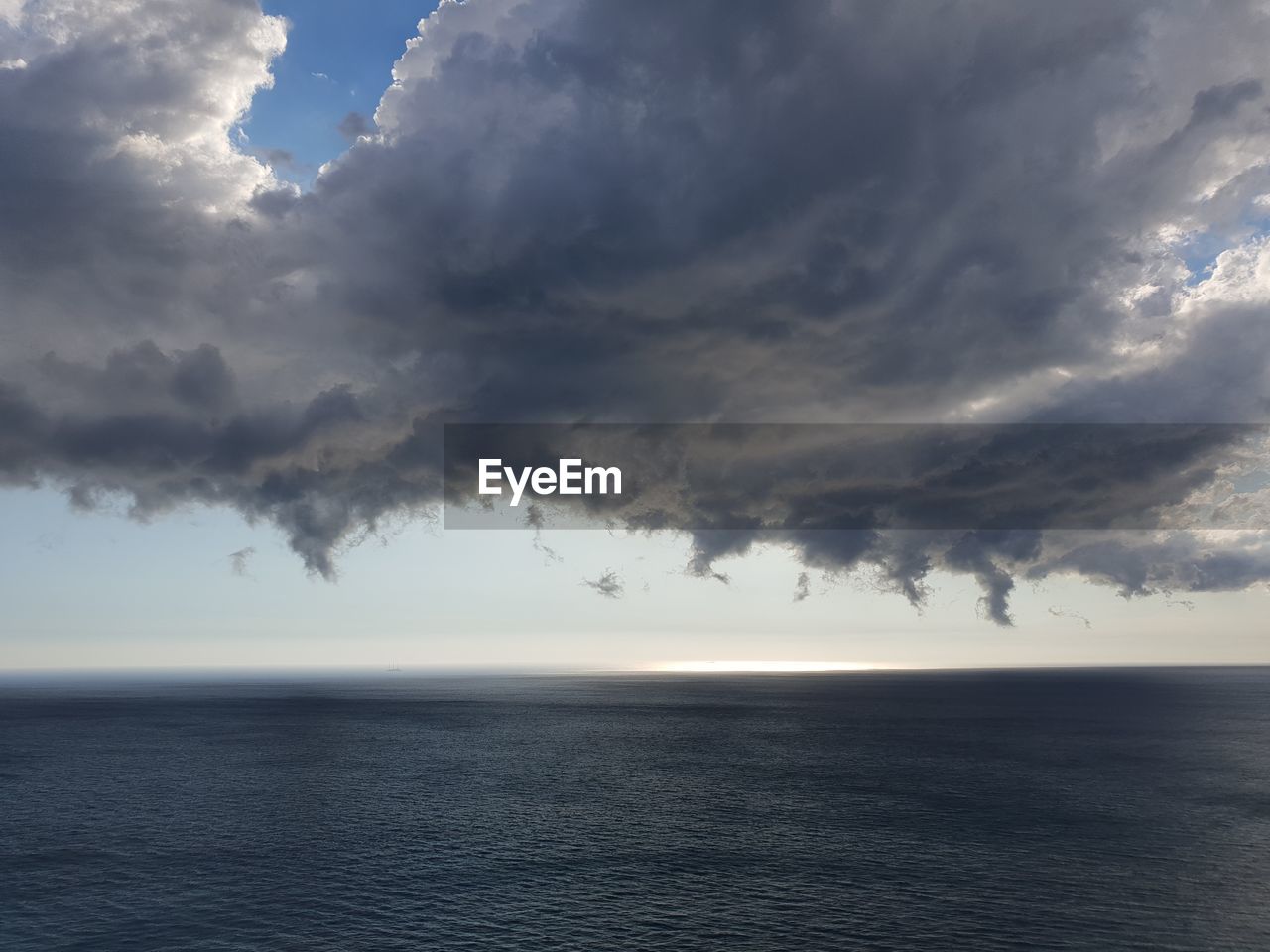 SCENIC VIEW OF SEA AGAINST STORM CLOUDS IN SKY