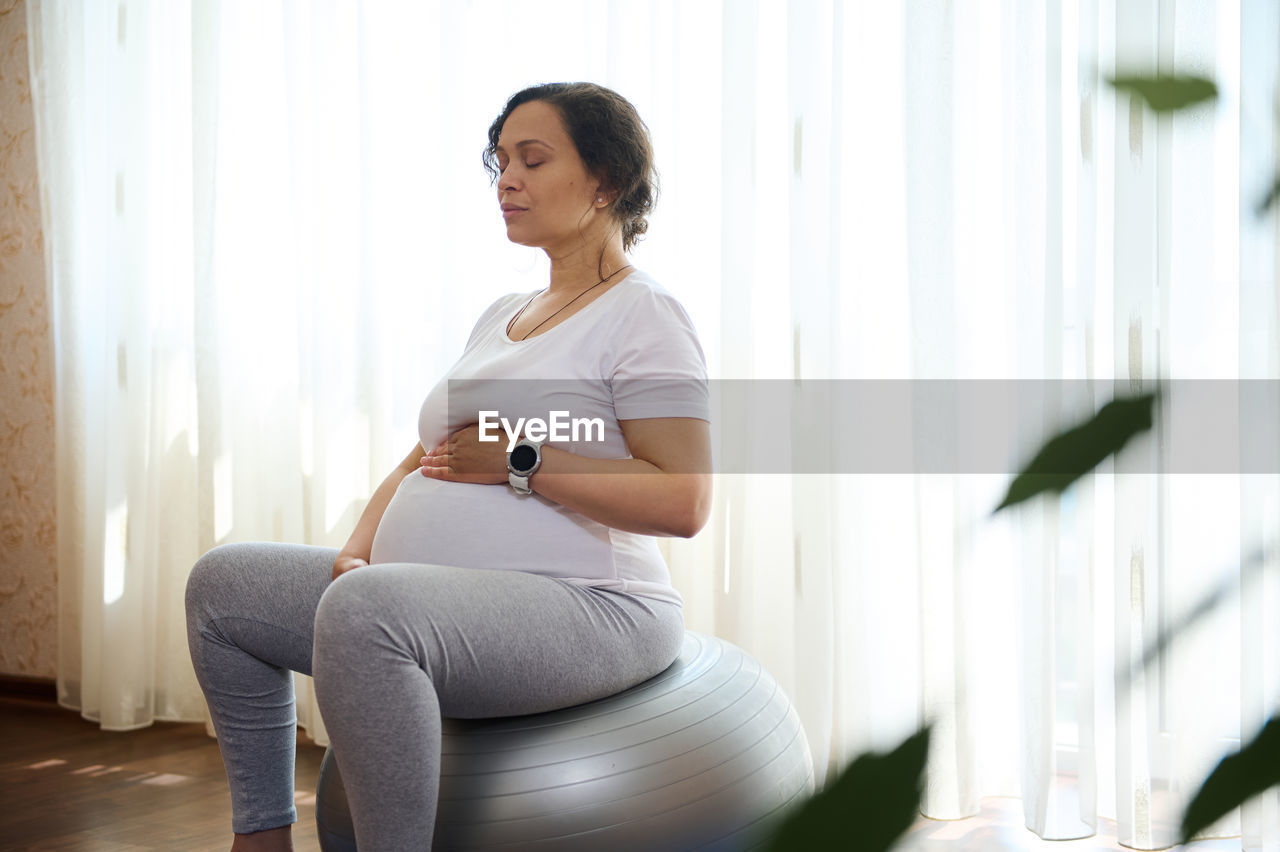 side view of young woman exercising at home