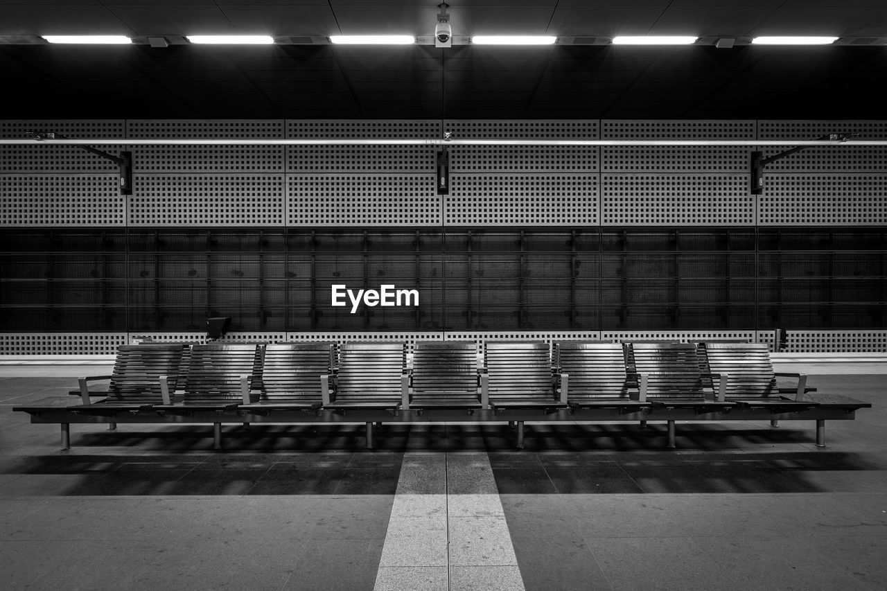 Empty chairs at illuminated subway platform
